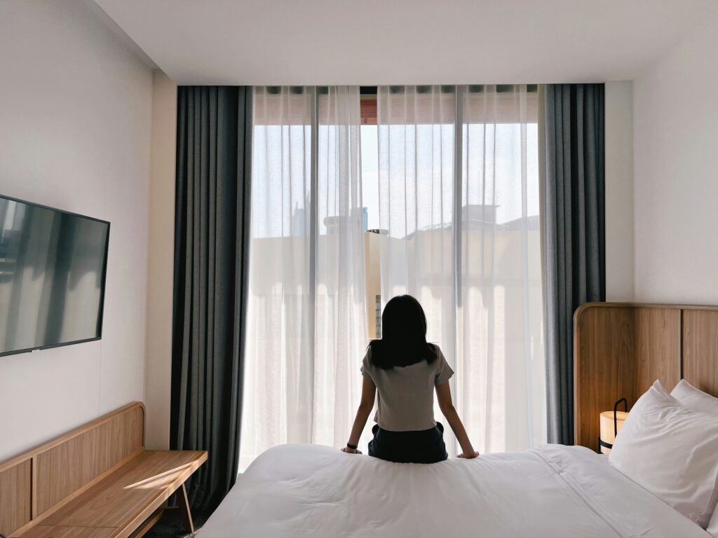 A woman relaxing on bed in hotel room