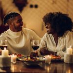 African american couple having romantic date and drinking wine at home