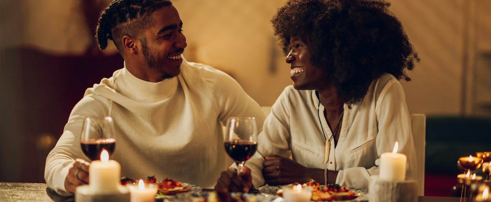 African american couple having romantic date and drinking wine at home