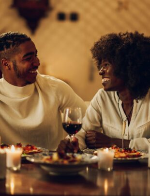 African american couple having romantic date and drinking wine at home