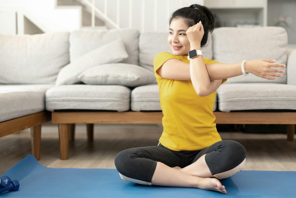 Attractive young woman doing yoga stretching yoga online at home. Self-isolation is beneficial