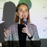 Confident young woman speaking into microphone