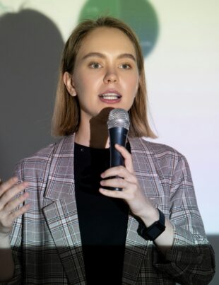 Confident young woman speaking into microphone