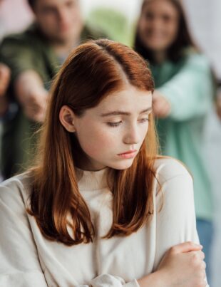 cropped view of group of teenagers bullying girl