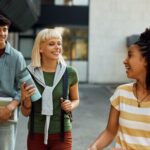 Multiracial group of happy college friends talking at campus.