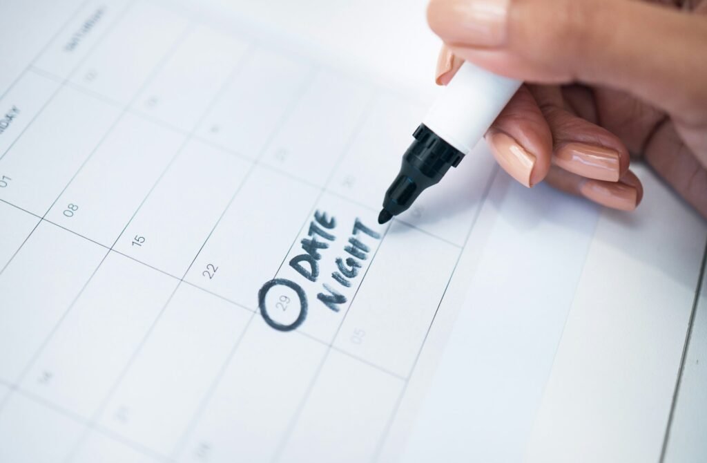 Person, hand and marker on calendar for date, schedule planning or agender on paper on office desk.