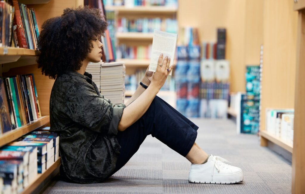 University, library book and girl student learning, reading and studying by school bookshelf for kn