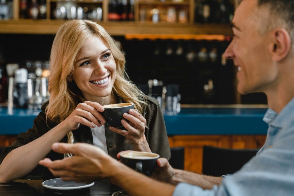 Woman listening to her husband man boyfriend while drinking coffee in restaurant cafe on a date