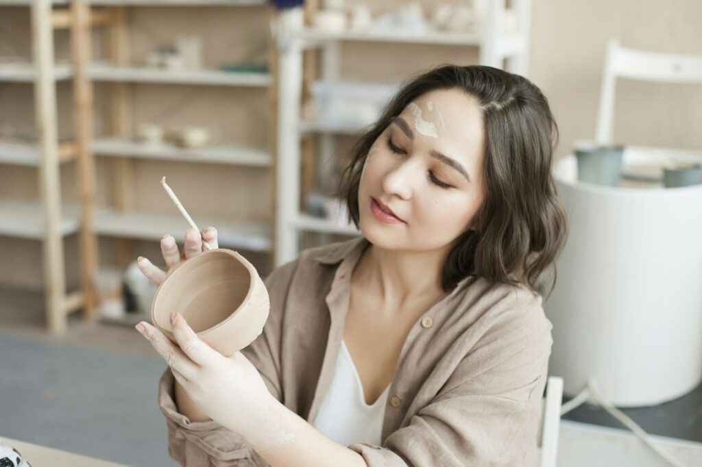 Woman making handmade clay pottery bowl at the class at the studio at artclass, arts and crafts