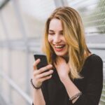 Young woman using smartphone laughing