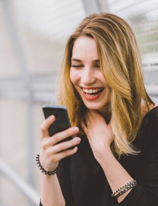 Young woman using smartphone laughing