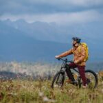 Active man on bike in the middle of autumn nature, admire mountains. Healthy lifestlye concept.