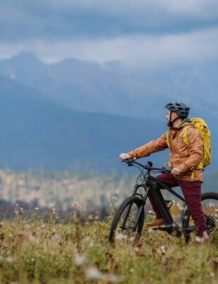 Active man on bike in the middle of autumn nature, admire mountains. Healthy lifestlye concept.