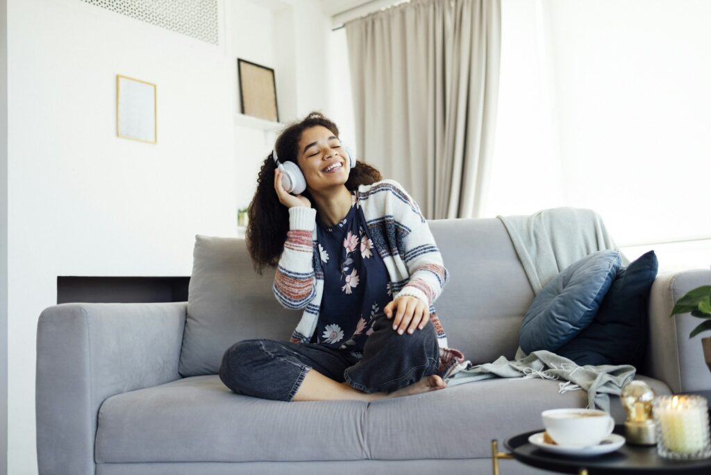 African millennial woman wearing wireless headphones,