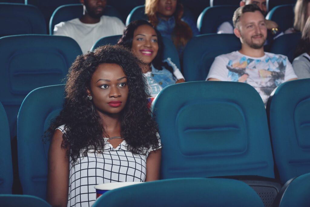 Africanl sitting alone and watching movie in cinema