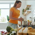 Attractive young woman cooking at the domestic kitchen