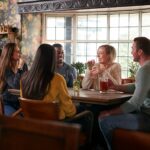 Group Of Friends Meeting For Lunchtime Drinks In Traditional English Pub