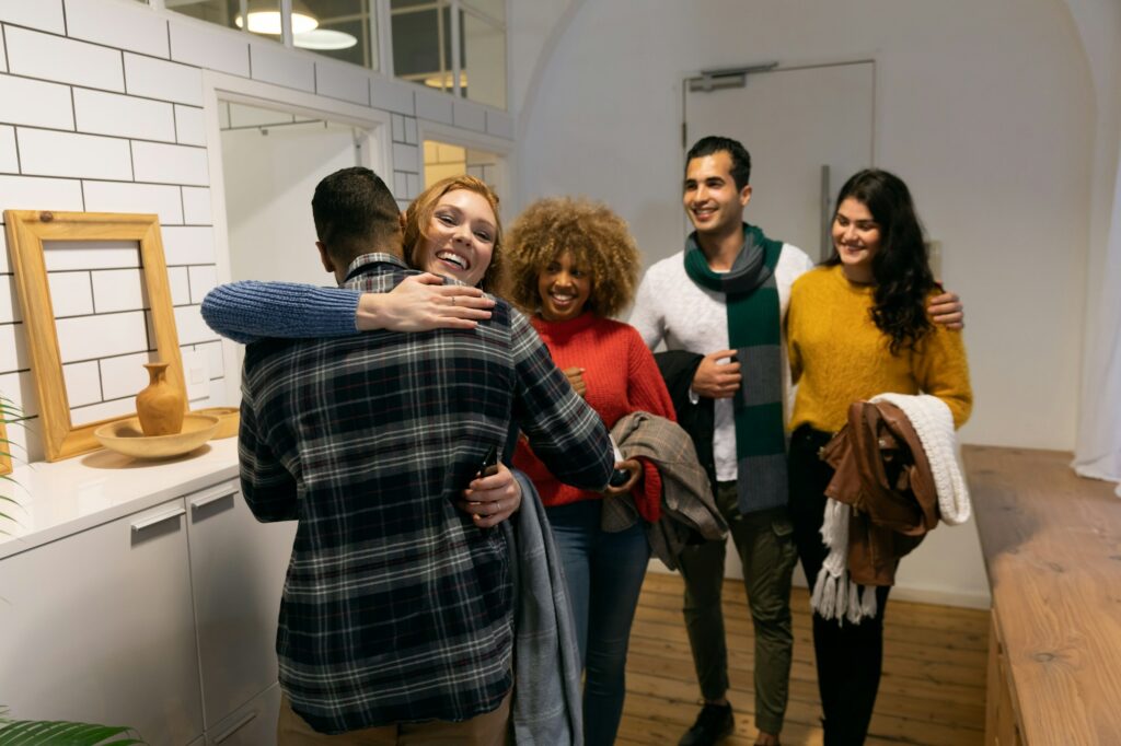 Millennial adult friends socialising together at home