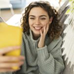 Pretty woman making video call with smartphone, at home