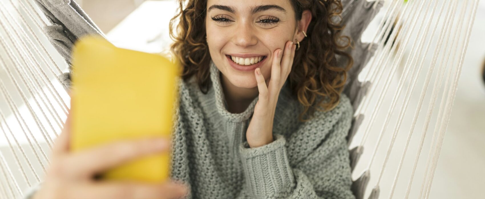 Pretty woman making video call with smartphone, at home