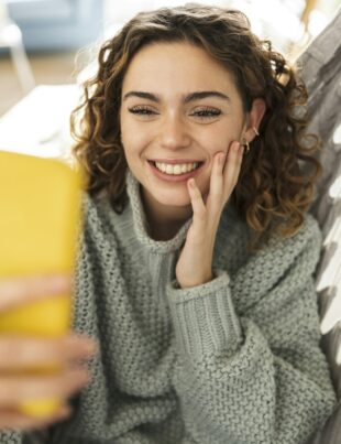 Pretty woman making video call with smartphone, at home