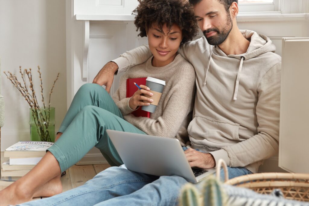 Relationship and technology concept. Relaxed couple embrace, look at laptop, check news feed in soci