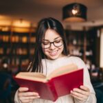 Young beautiful student girl reading a book