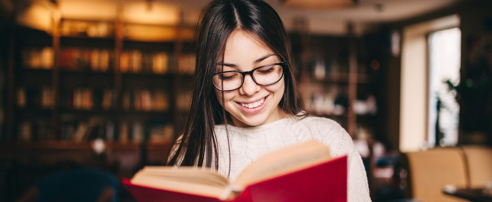 Young beautiful student girl reading a book