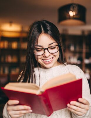 Young beautiful student girl reading a book