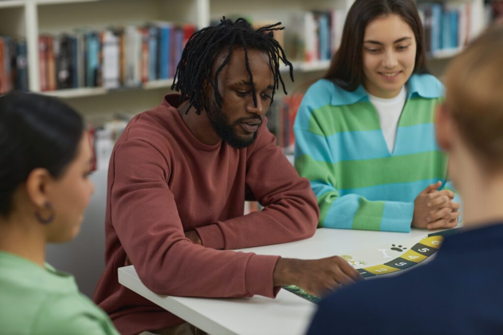 Young black man playing board games with group of friends