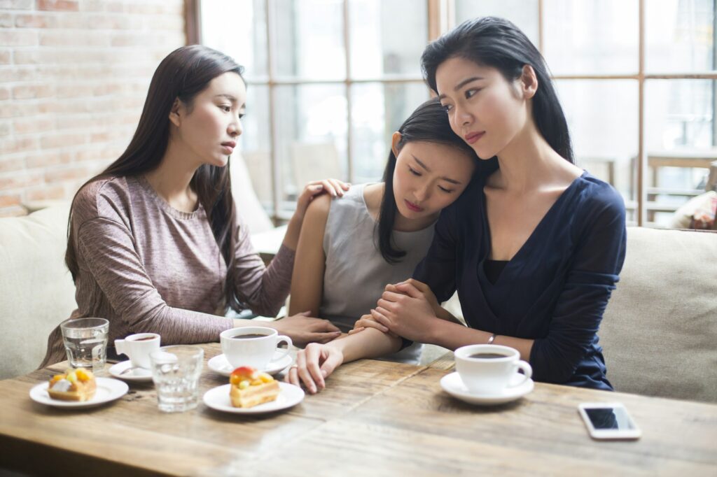 Young women comforting their friend