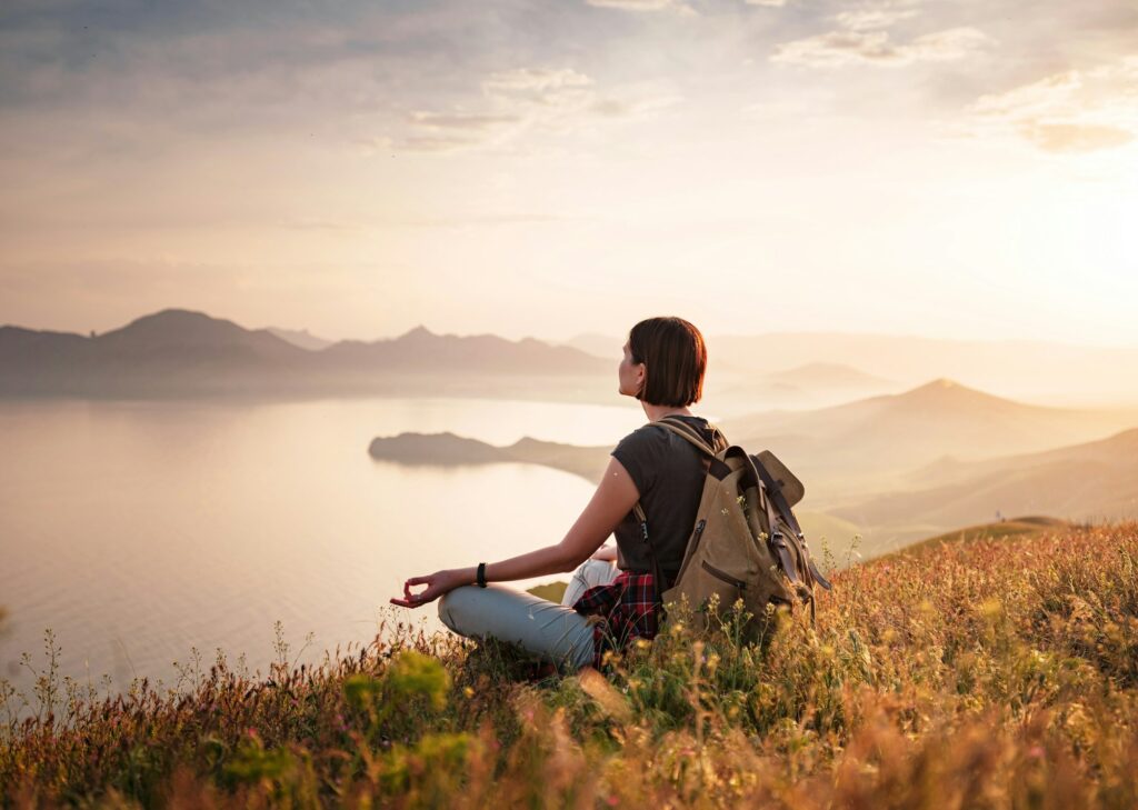 A young Asian woman with a backpack hiking in the summer.