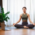 Asian woman yoga teacher filming yoga online class