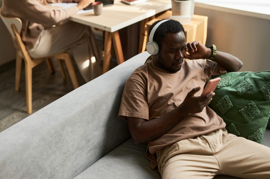 Black man using headphones listening to music at home