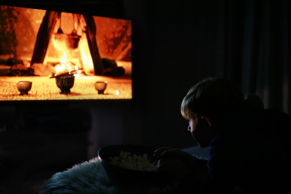 Boy watches movie in the dark room