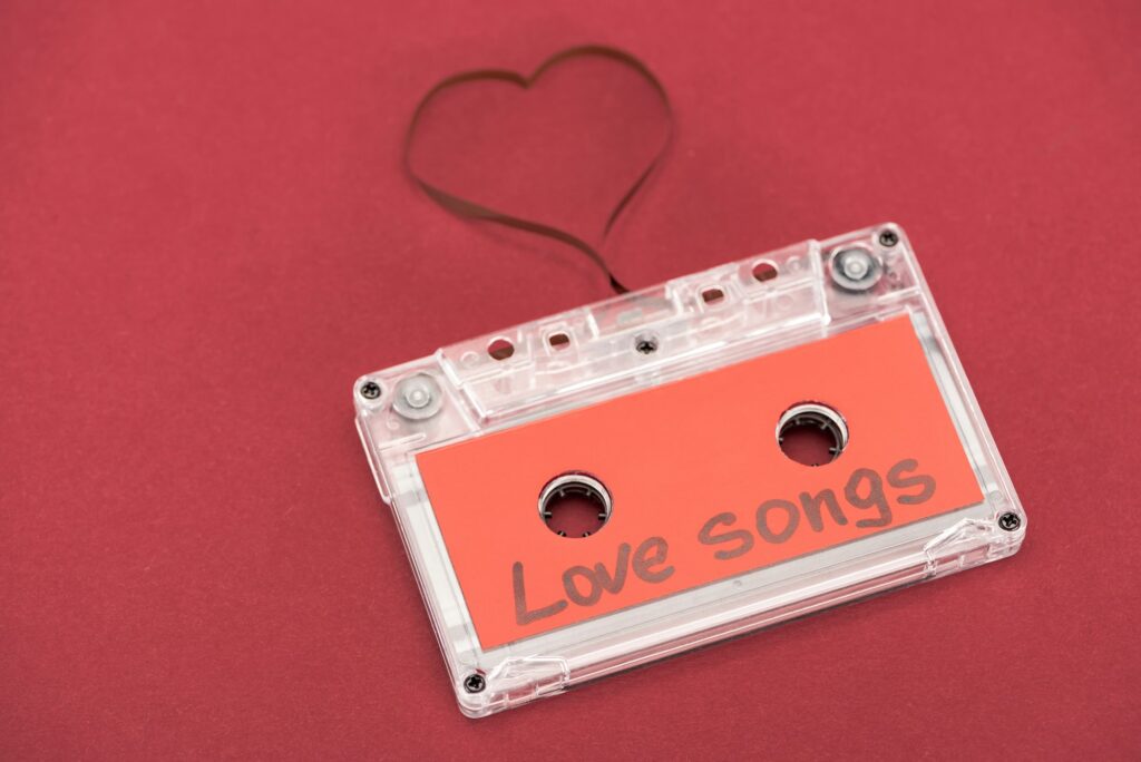 close up view of audio cassette with lettering love songs and heart symbol made of tape isolated on