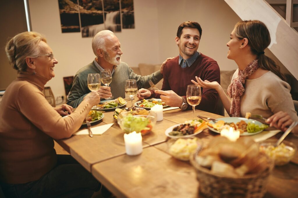 Happy family communicating while eating dinner at dining table.