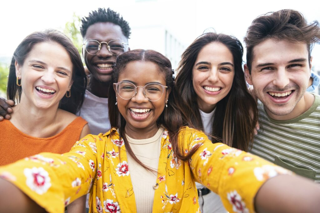 Multicultural friends taking selfie picture outside on city street