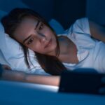 Woman watching movie on smartphone at night