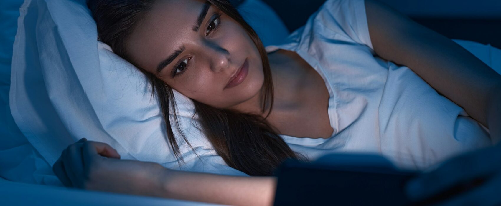 Woman watching movie on smartphone at night