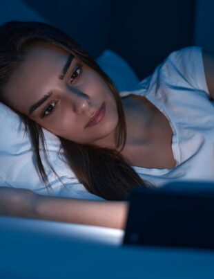 Woman watching movie on smartphone at night