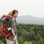 Young hiker contemplating forest