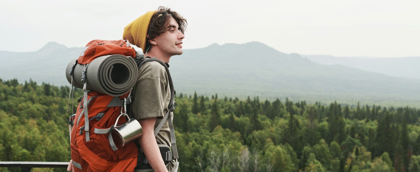 Young hiker contemplating forest