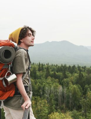 Young hiker contemplating forest