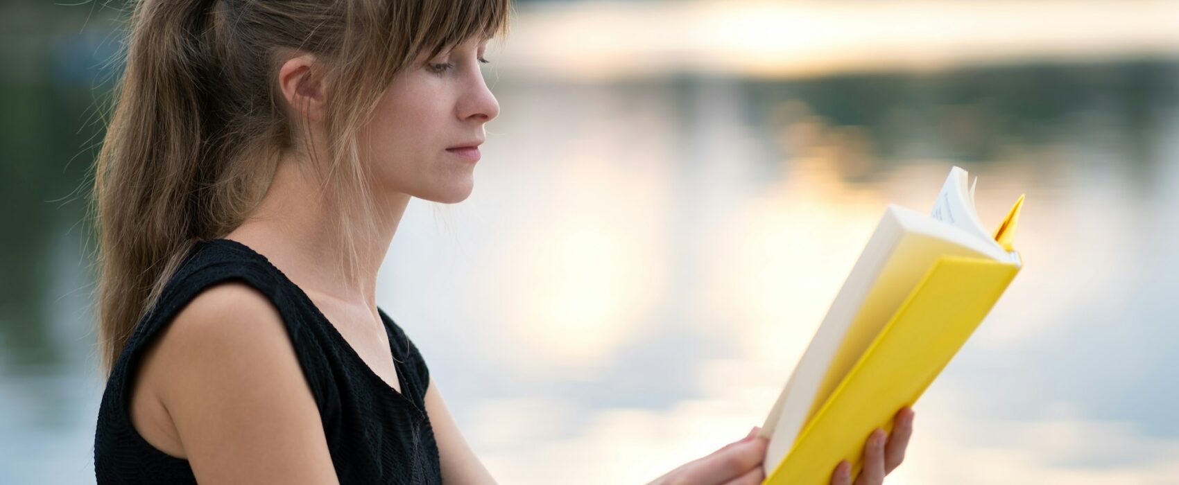 Young woman resting in summer park reading a book. Education and sudy concept