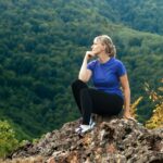 active woman admiring the nature of the mountains during a solo hiking trip