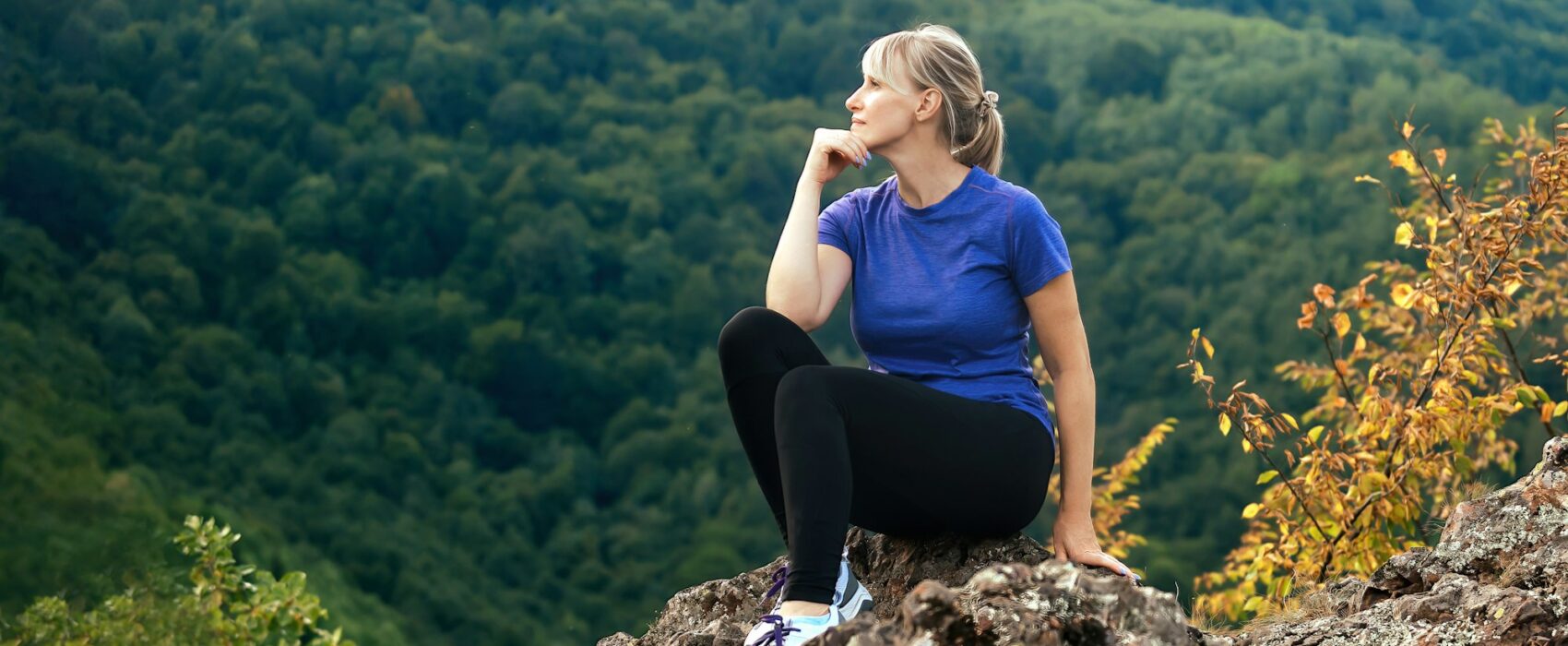 active woman admiring the nature of the mountains during a solo hiking trip