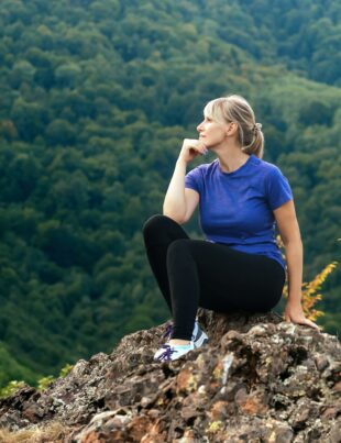 active woman admiring the nature of the mountains during a solo hiking trip