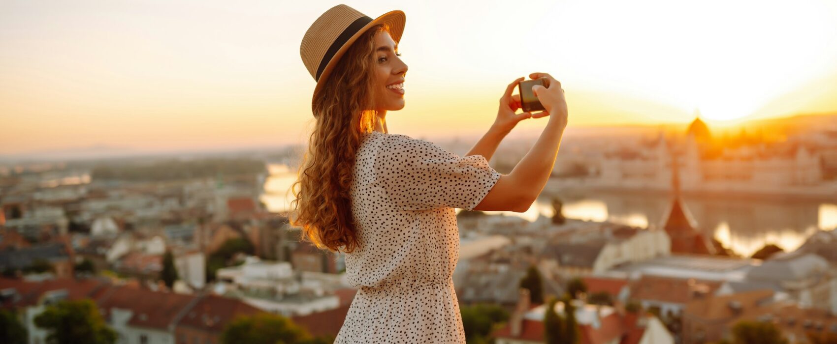 Travel in Europe. Young woman enjoys sunrise. The concept of travel, tourism, vacation and freedom.