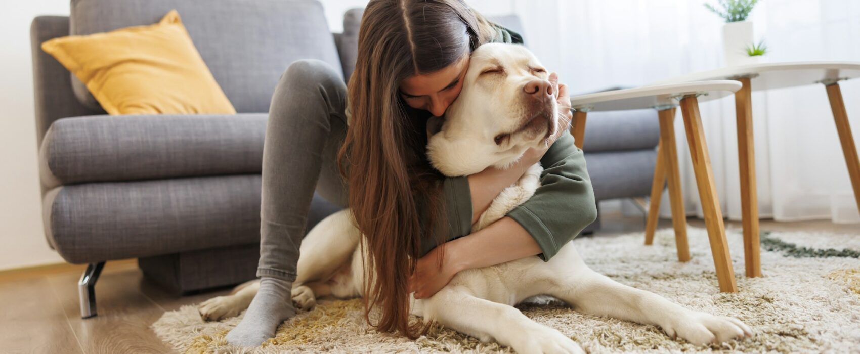 Woman cuddling and hugging her pet dog